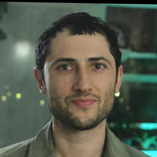 Jasper Hall: a portrait in a workshop, teal aquarium light behind.